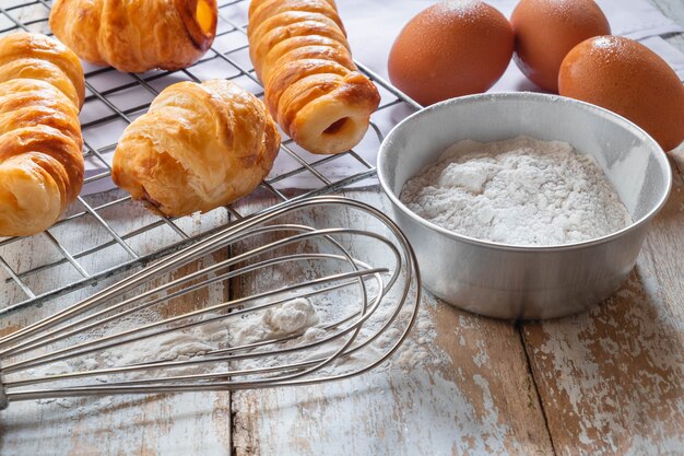 Pain et bol de farine sur fond de bois