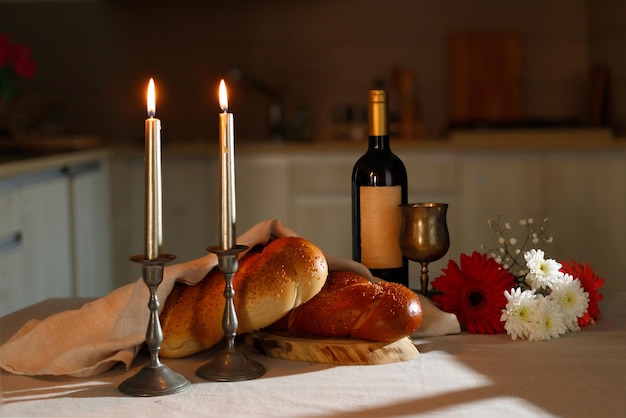 Pain challah recouvert d'une serviette spéciale vin de shabbat sur la table de cuisine Rituel de Shabbat juif traditionnel Shabbat Shalom