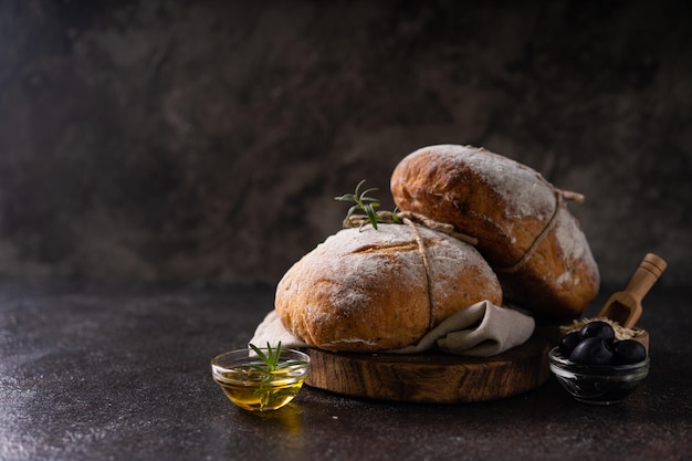 Pain ciabatta artisanal bio frais sur fond rustique foncé pain au levain