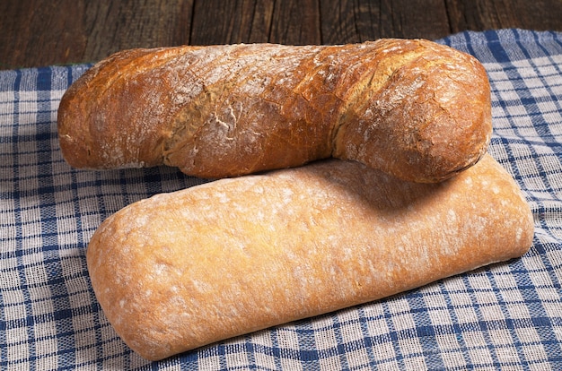 Pain ciabatta blanc et brun sur nappe bleue