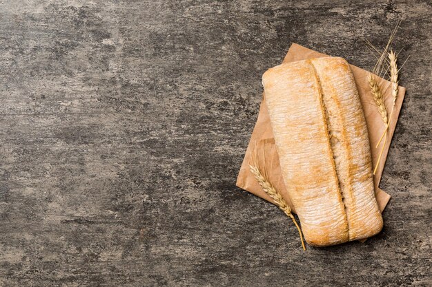 Pain ciabatta frais sur serviette sur fond rustique vue de dessus de pain italien