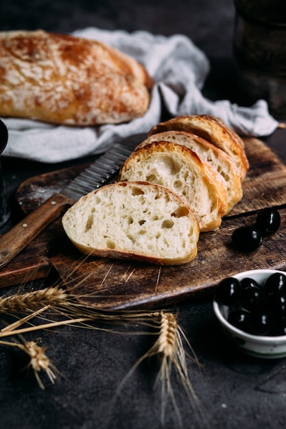 Pain ciabatta maison Tranches de pain sur une planche de bois