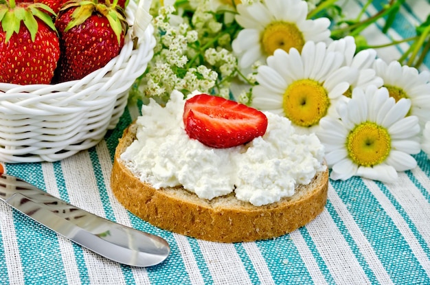 Pain avec crème de caillé et fraises sur une serviette verte