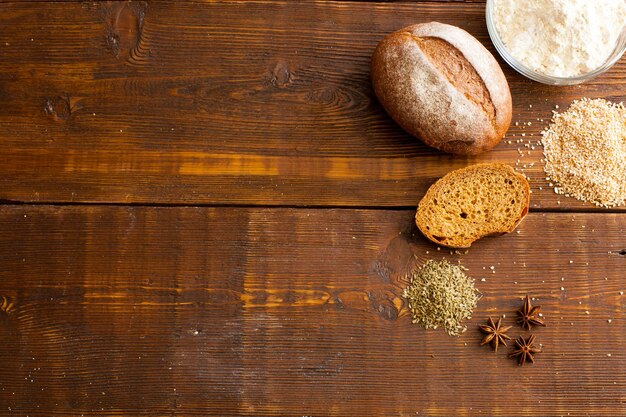 Pain croustillant brun frais avec pain de farine de pain et grain de blé sur la table en bois