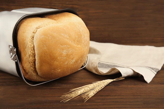 Pain cuit dans une machine à pain sur une table en bois