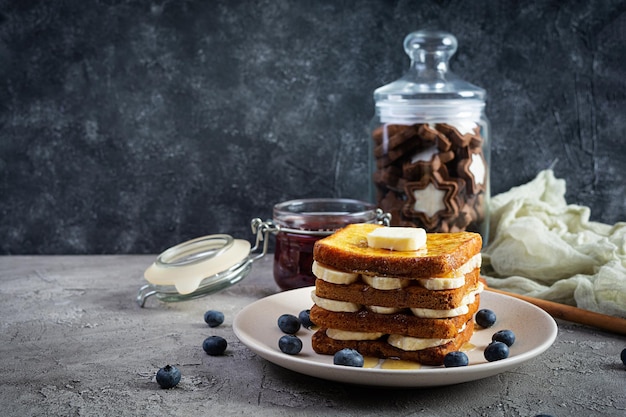 Pain doré avec confiture de banane, myrtille, miel et fraise. Délicieux petit-déjeuner ou brunch le matin avec du pain grillé et des biscuits