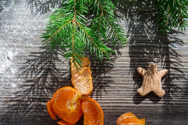 Pain d'épice aux mandarines et biscuits sur une table en bois saupoudrée de farine blanche sous forme de neige