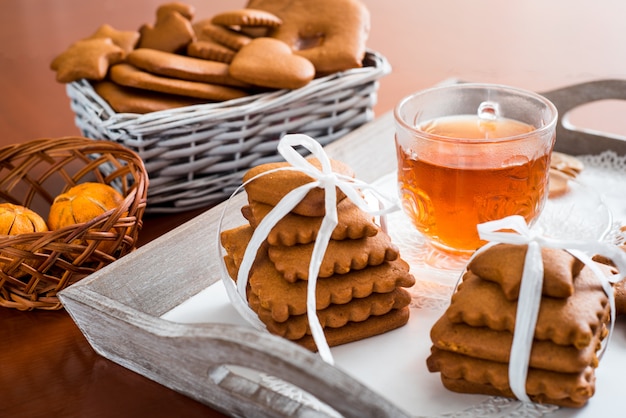 Pain d&#39;épice avec du thé chaud sur un plateau. Un grand ensemble de biscuits au gingembre sur une table en bois