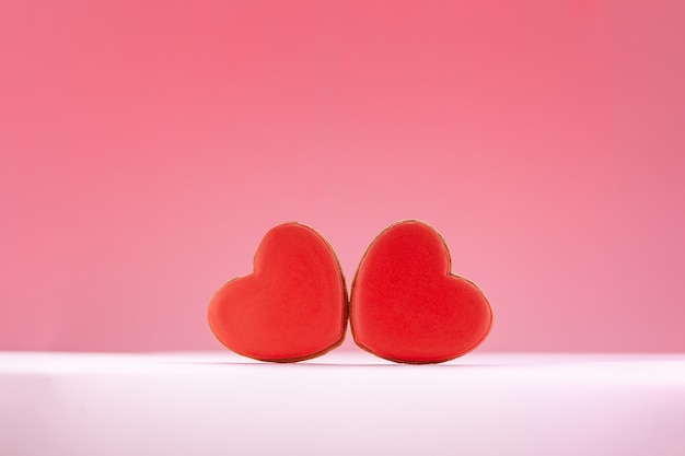 Pain d'épice en forme de coeur rouge pour la Saint Valentin, la fête des mères ou un anniversaire sur fond rose.