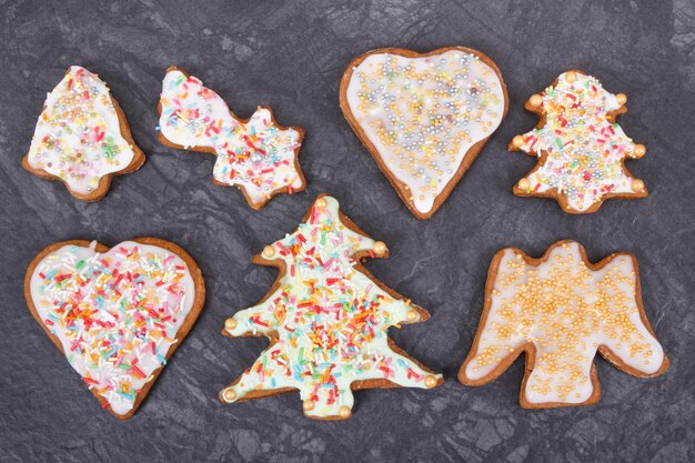 Pain d'épice frais cuit au four en forme de coeur et d'étoile d'arbre de Noël avec des décorations colorées pour Noël