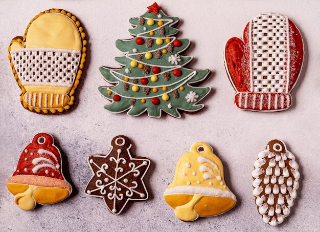 Pain d'épice de Noël sur fond gris. Sapin, flocon de neige, épicéa, mitaine, cônes, cloche.