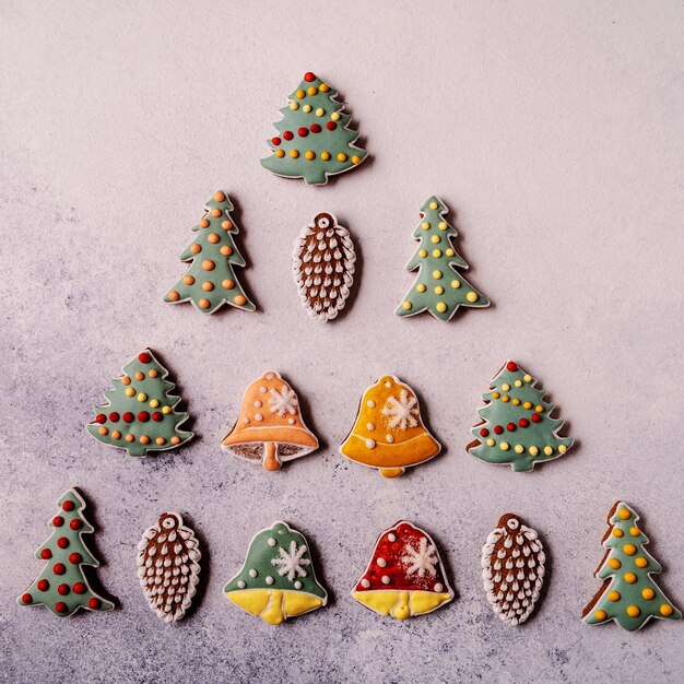 Pain d'épice de Noël sur fond gris. Sapin, flocon de neige, épicéa, mitaine, cônes, cloche.