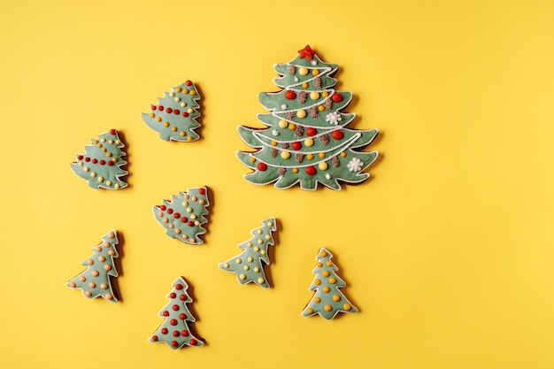 Pain d'épice de Noël sur fond jaune. Forme de sapin, pose plate.