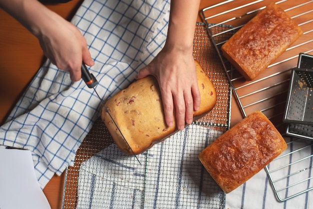 Pain fait maison sur la table de cuisine avec la coupe de main de femme