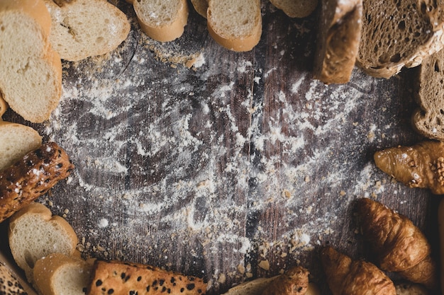 Pain et farine à pâtisserie sur une table en bois