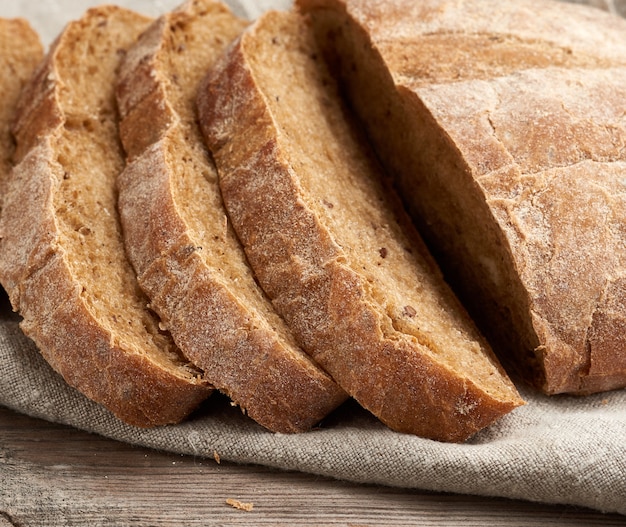 Pain de farine de seigle au four rond tranché sur une serviette en lin gris