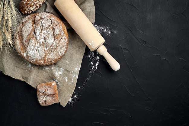 Pain fraîchement cuit sur la vue de dessus de table de cuisine sombre