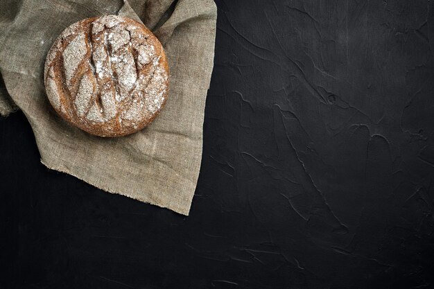 Pain fraîchement cuit sur la vue de dessus de table de cuisine sombre