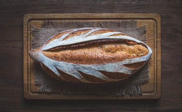 Photo pain frais au levain naturel sur fond de bois miche de pain de grains entiers