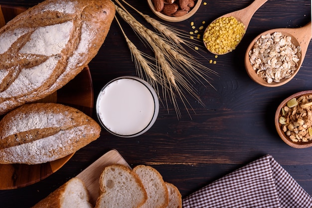 Pain frais avec du lait sur une table en bois noire.