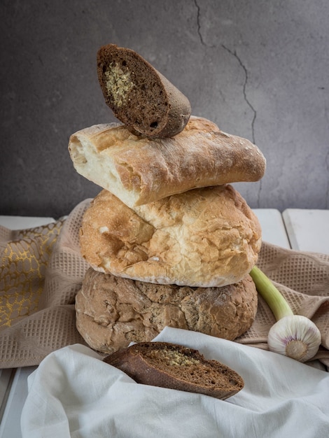 Pain frais fait maison à l'ail sur une serviette beige et une table en bois