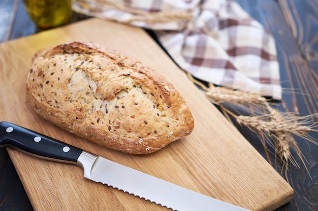 Pain frais sur une planche à découper en bois à la table de la cuisine