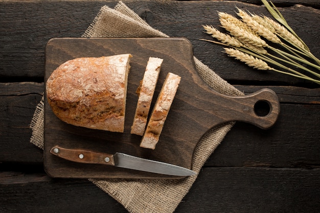 Pain frais sur une planche avec du blé sur bois