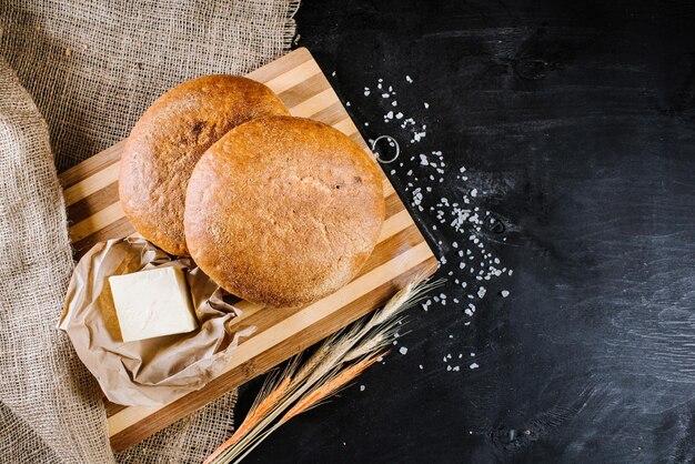 Pain frais sucré avec des ingrédients sur fond de bois noir