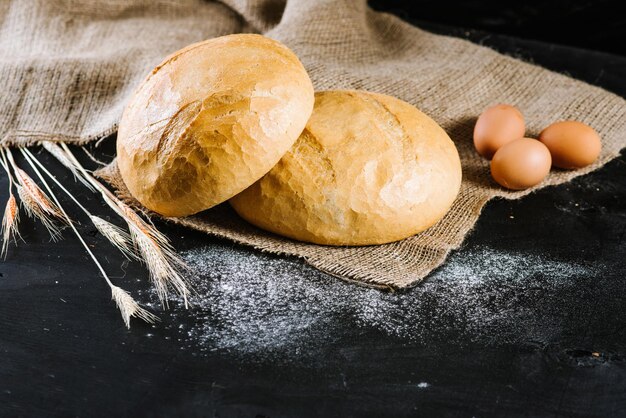 Pain frais sucré avec des ingrédients sur fond de bois noir