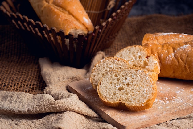 Pain français saupoudré de sucre glace sur une planche à découper en bois