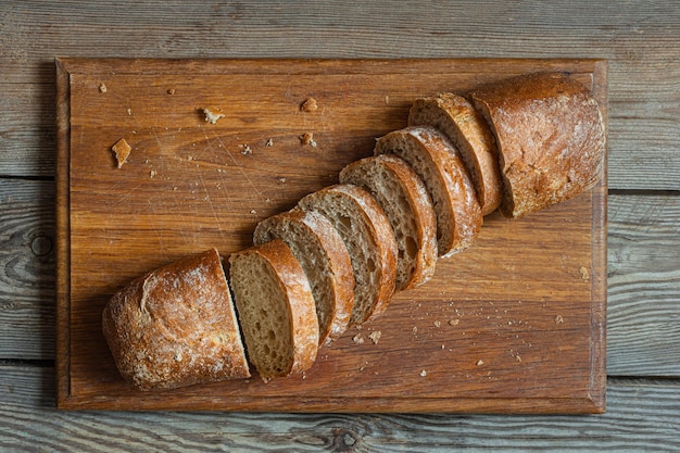 Photo pain de grain entier fraîchement cuit sur fond de bois