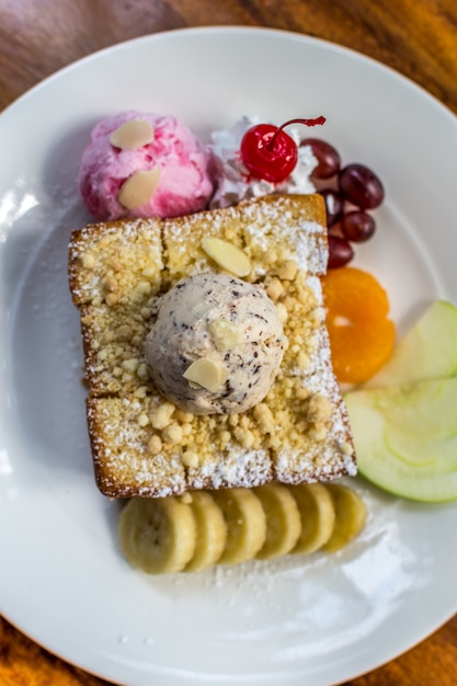 Pain grillé au miel avec glace et fruits et sirop au chocolat et miel