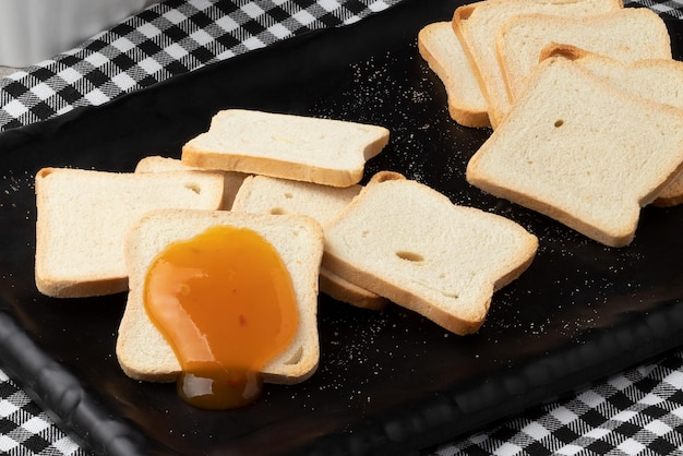 Pain grillé avec de la confiture de mangue sur une planche à découper