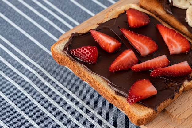 Pain grillé avec pâte de chocolat et fraise coupée