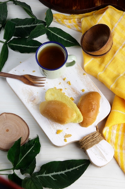 Pain grillé sur un plateau en bois blanc avec une tasse de thé