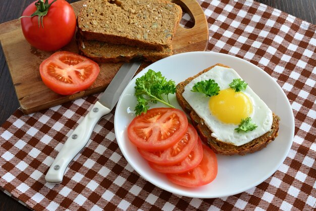 pain grillé sain avec des tranches d'œuf frit et de tomate, gros plan