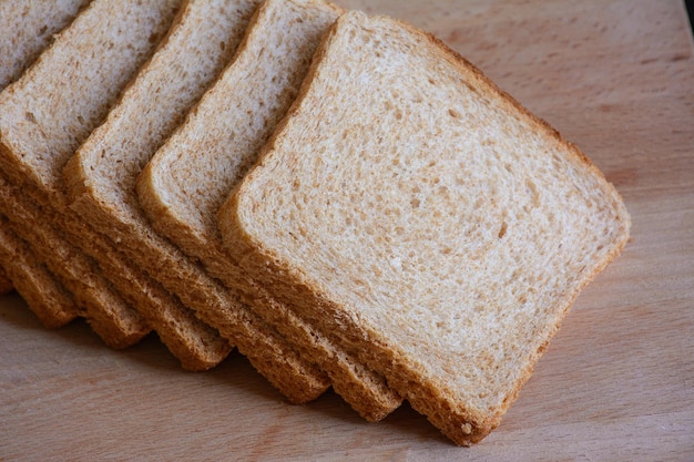 Pain grillé tranché sur une planche de bois clair