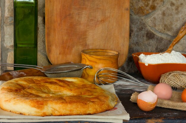 Pain italien traditionnel, focaccia, oeuf cassé avec le jaune. Style rustique.