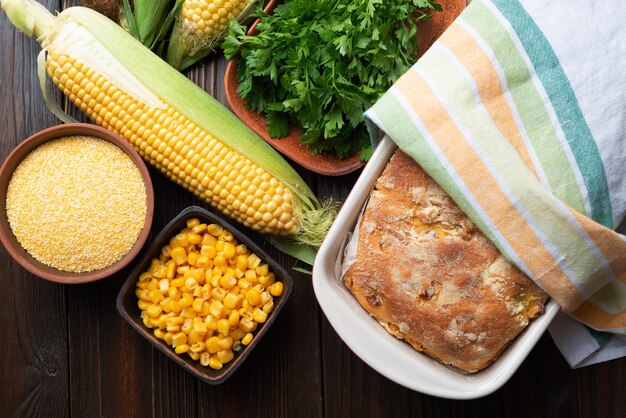 Pain de maïs dans un plat de cuisson en céramique sur une table de cuisine en bois, vue à plat