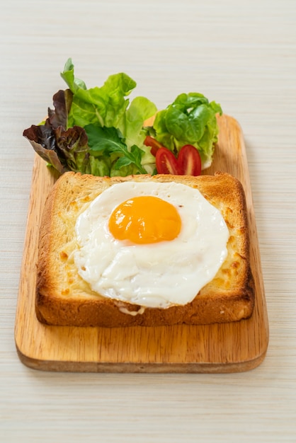 pain maison grillé avec du fromage et un œuf au plat sur le dessus avec une salade de légumes pour le petit-déjeuner