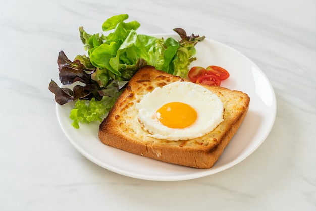 pain maison grillé avec du fromage et un œuf au plat sur le dessus avec une salade de légumes pour le petit-déjeuner