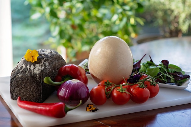 Photo pain maison œuf d'autruche et légumes paprika tomates piment salade d'oignons ingrédients pour faire une omelette shakshuka soft selective focus