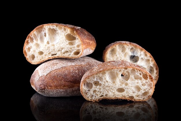 Pain de mie italien ciabatta. Pain maison fraîchement sorti du four isolé sur fond noir. Une alimentation saine et une boulangerie traditionnelle, un concept de pain de cuisson.