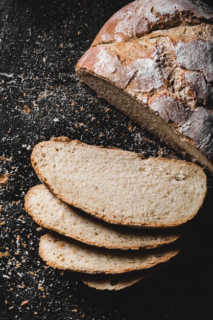 Un pain noir fait maison tranché en tranches et poussiéré de farine