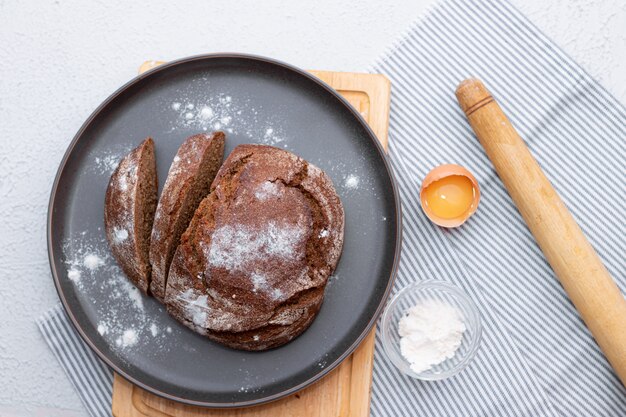 Pain noir. Gateau maison. Le pain noir est saupoudré de farine. Pain de seigle artisanal et de farine blanche fraîchement cuit. La vue d'en haut.