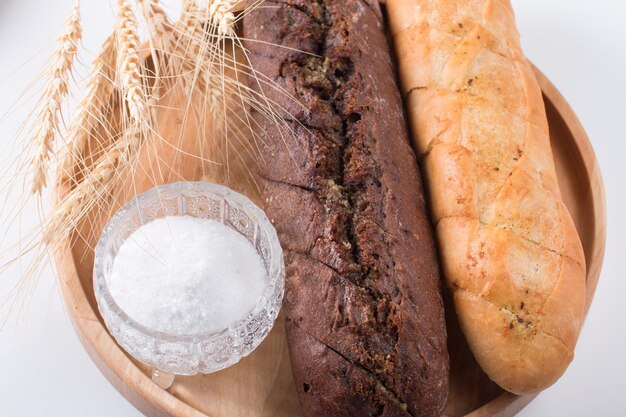 Pain noir rond frais avec une croûte croustillante baguette à l'ail blanc et noir Gros plan sur fond blanc