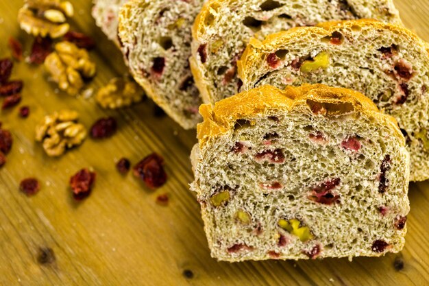 Pain de noix de canneberge au levain tranché fraîchement cuit sur la table.