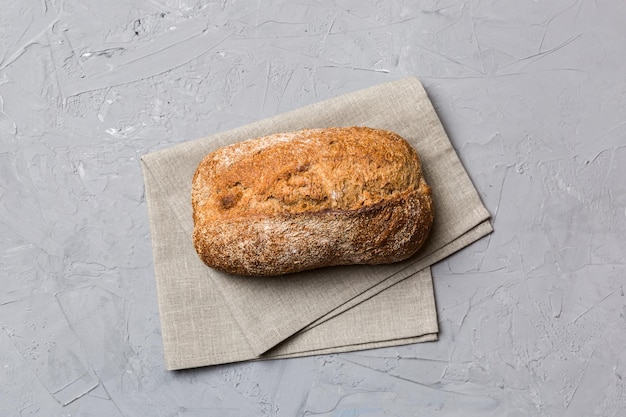 Pain de pain de blé entier fait maison frais sur une serviette sur fond rustique vue de dessus de pain frais