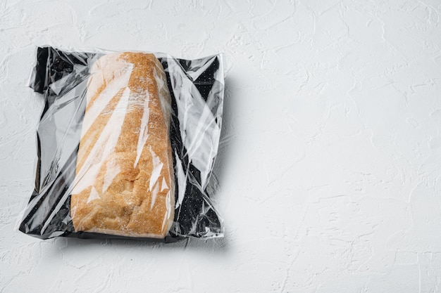 Pain panini ciabatta dans un sac en plastique sur fond blanc avec espace pour copie et espace pour le texte