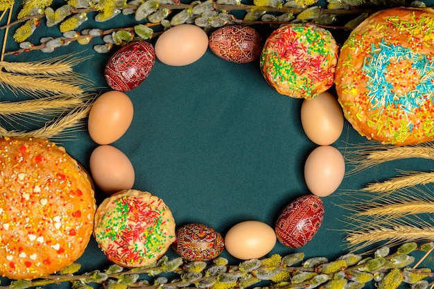 Pain de Pâques avec des branches de saule pysanka sur une texture de fond bleu monochrome